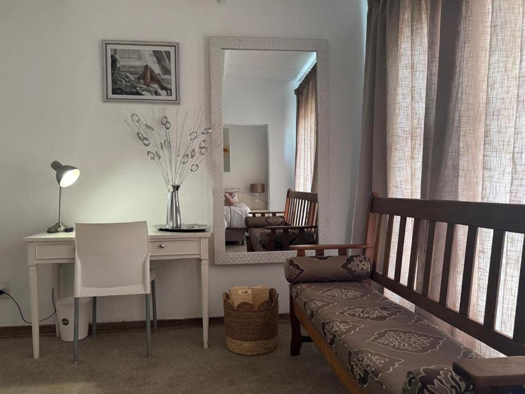 1 dormitorio con escritorio y 1 cama con espejo en At Harmony, en Germiston