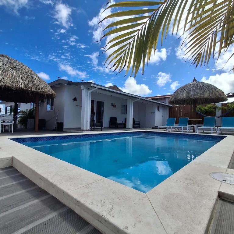 a swimming pool in front of a house at Caribbean Breeze- 4 Bedroom- 4 ensuite bathrooms in Oranjestad