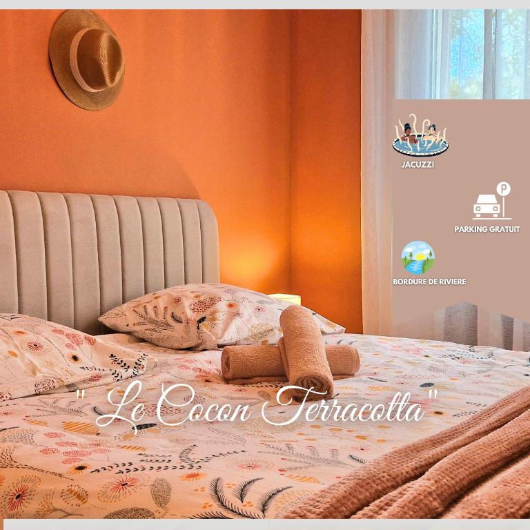 a stuffed animal sitting on top of a bed at Le Cocon Terracotta & Spa in Saint-Laurent-de-Médoc