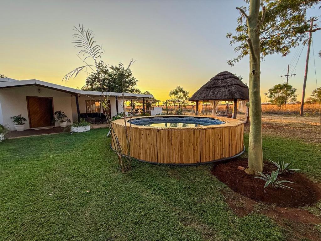 a hot tub in a yard next to a house at Lemón Phoenix in Bela-Bela