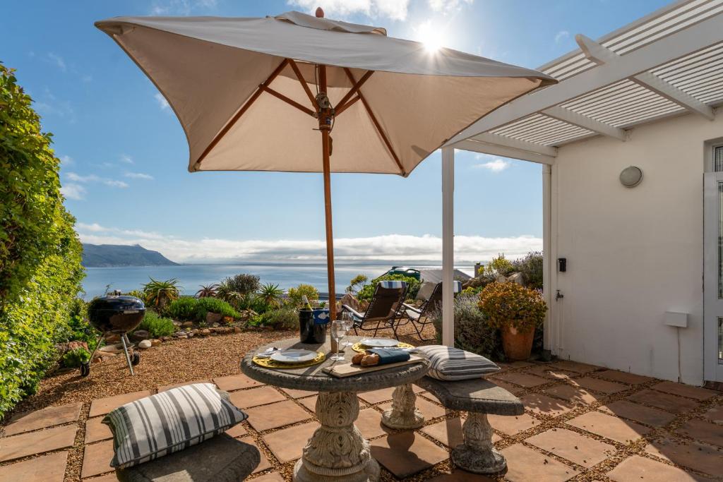 a table with an umbrella on a patio at Spectacular views Simonstown in Cape Town