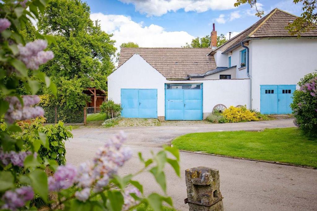 a house with blue garage doors in a driveway at Chalupa u Hejsků in Jilem