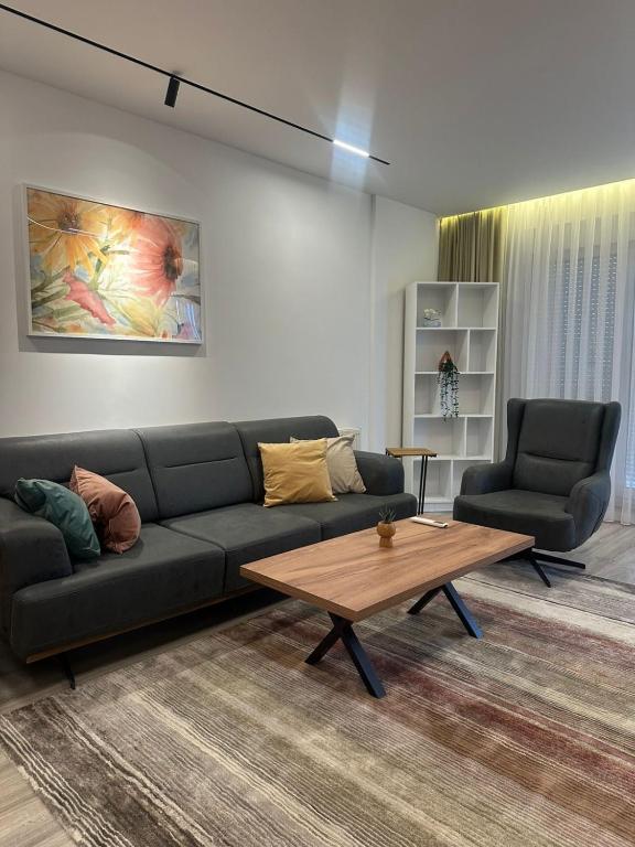 a living room with a couch and a coffee table at Aparte - Emshir in Prishtinë
