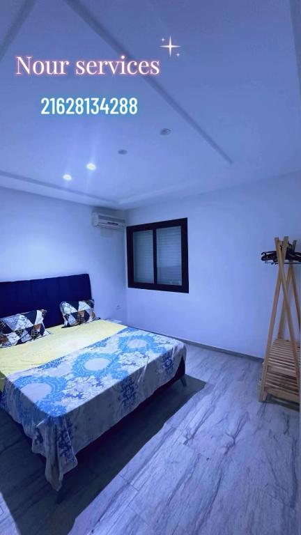 ein Schlafzimmer mit einem Bett und einem Stativ in der Unterkunft Residence cham S2 N4 in Tunis