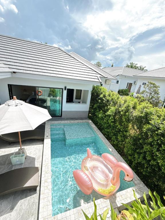 a swimming pool with a pool noodle in front of a house at Aonang nine poolvilla resort in Ao Nang 