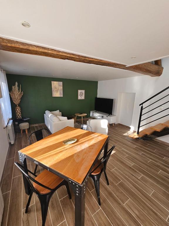 un soggiorno con un tavolo di legno e un divano di La P'tite Maison a Saint-Julien-sur-Cher