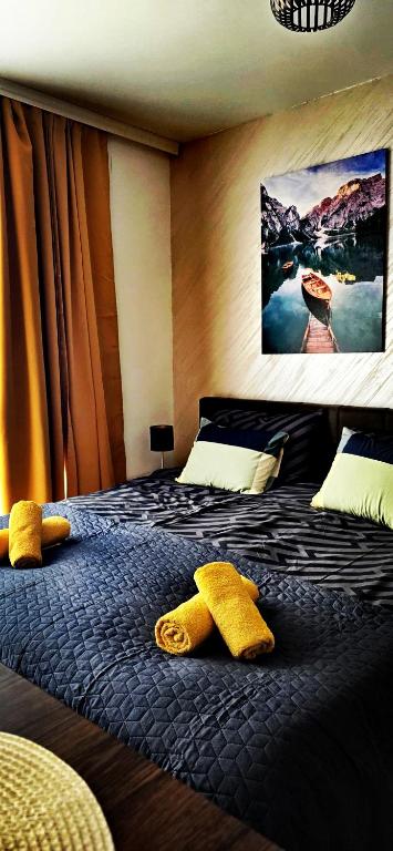 a bedroom with a bed with yellow towels on it at Apartments Ogi in Divčibare