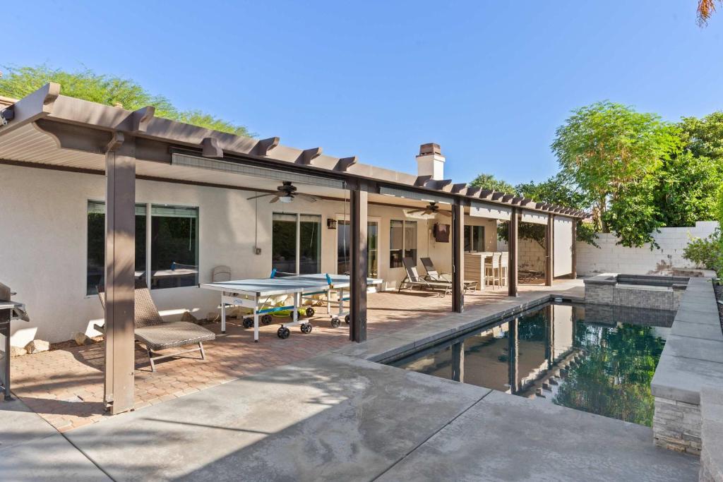 a patio with a pool and a table next to a house at The Deserts Best Kept Secret by Navigate Stays in Desert Groves Mobile Home Park