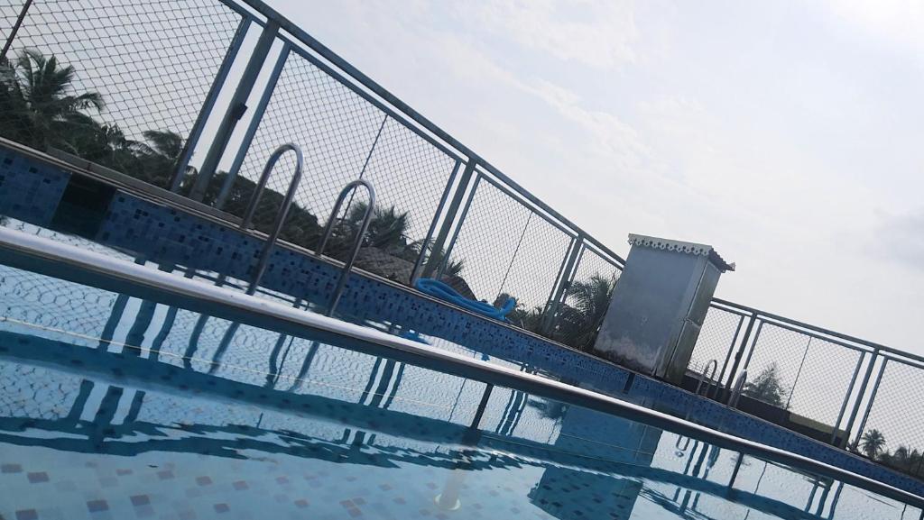 a metal fence next to a swimming pool at J0MAS 0utdoor 0Jost Stay in Baga