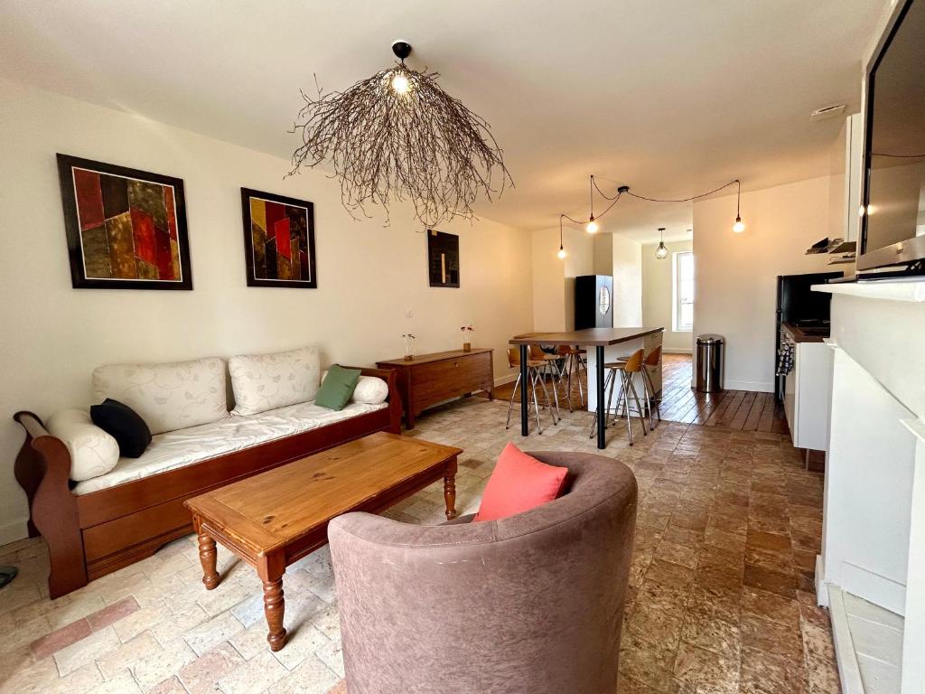 a living room with a couch and a table at Appartement duplex centre-ville entièrement rénové in Mortagne-au-Perche