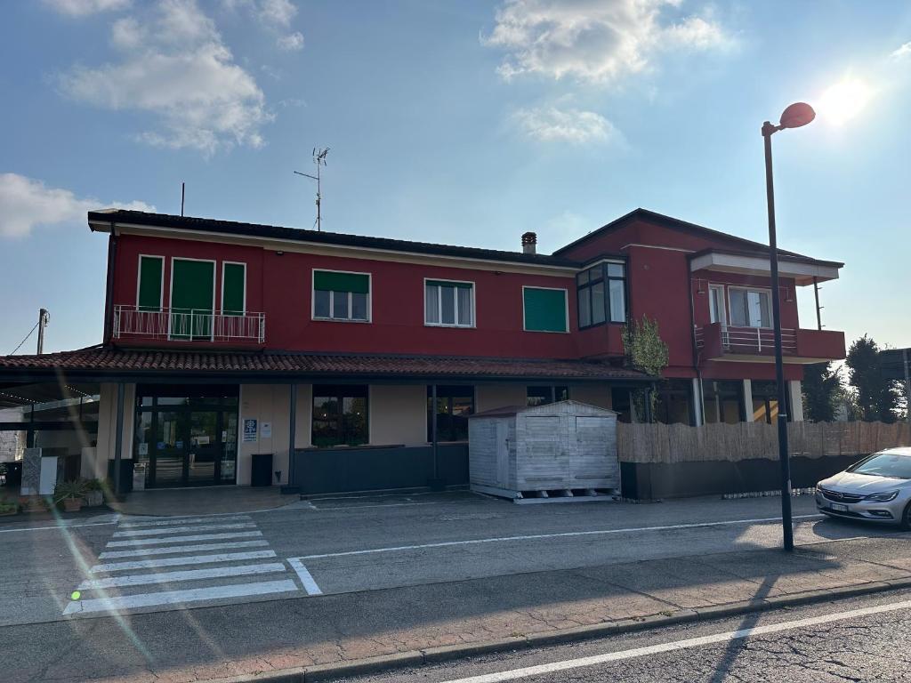 a red building with a car parked in front of it at Nazìonale Minerbe in Minerbe