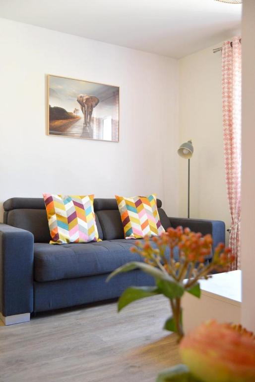 ein Wohnzimmer mit einer blauen Couch und Kissen in der Unterkunft Chez Léonore in Chartres