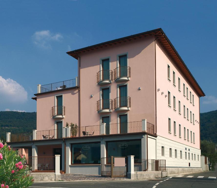 a large pink building with windows and balconies at International Hotel in Iseo