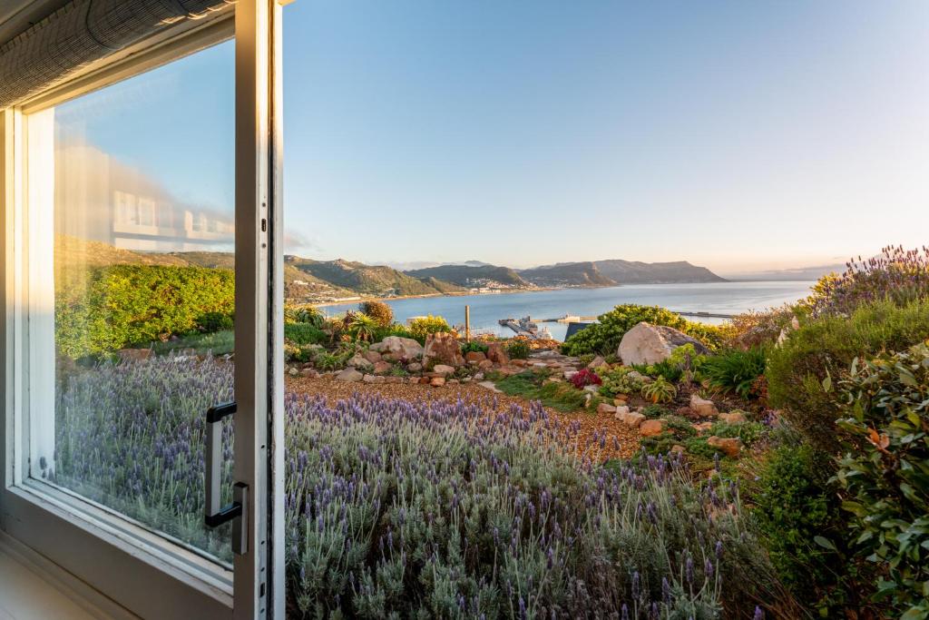a window view of a garden with purple flowers at Spectacular Sea Views Coastal Holiday Home in Cape Town