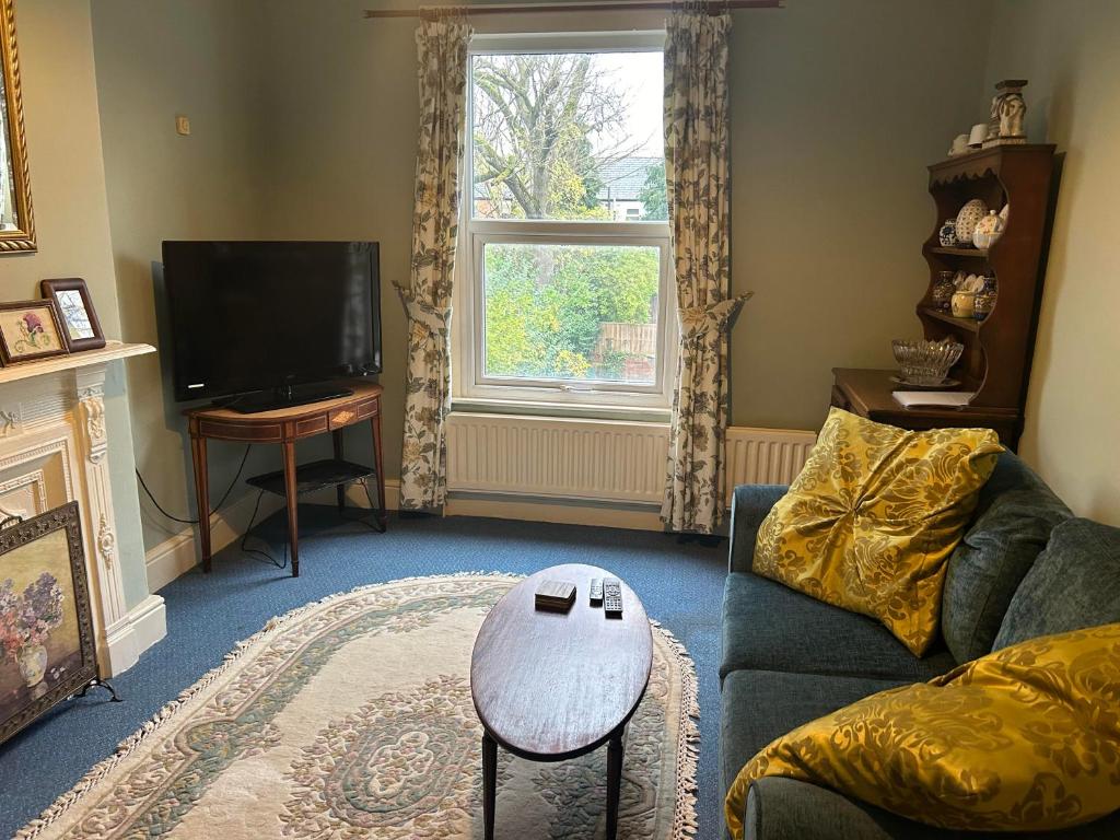 a living room with a couch and a tv at Grace Stays in Ellesmere Port