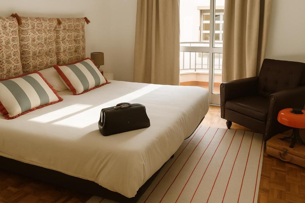 a hotel room with a bed with a black bag on it at Teatro View in Fundão