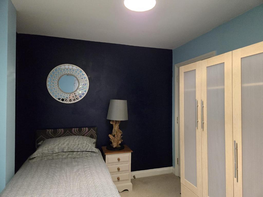 una camera da letto con un letto e uno specchio sul muro di Smiths Wharf, Wantage a Wantage