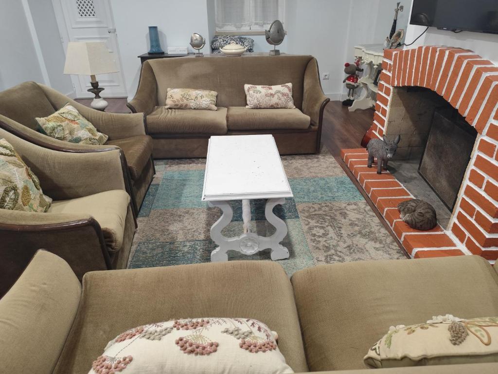 a living room with couches and a fireplace at Casa da Nogueira in Alvorninha