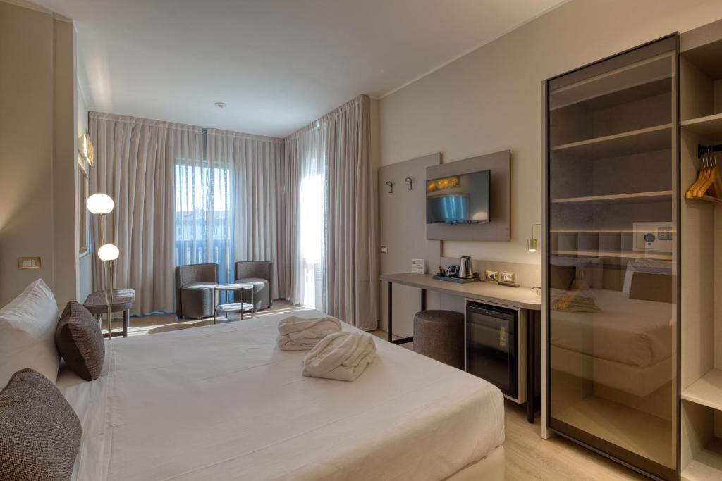 a hotel room with a white bed and a desk at Hotel Nasco in Milan
