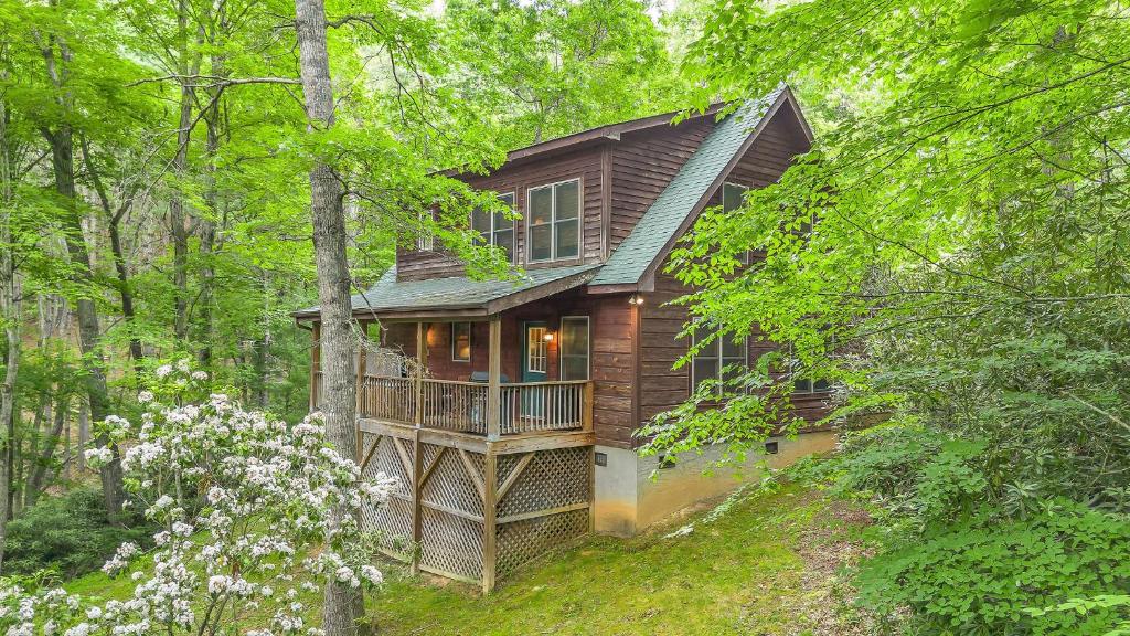 a wooden house with a balcony in the woods at Among the Laurels- Private Hot Tub and Fire Pit in Fleetwood