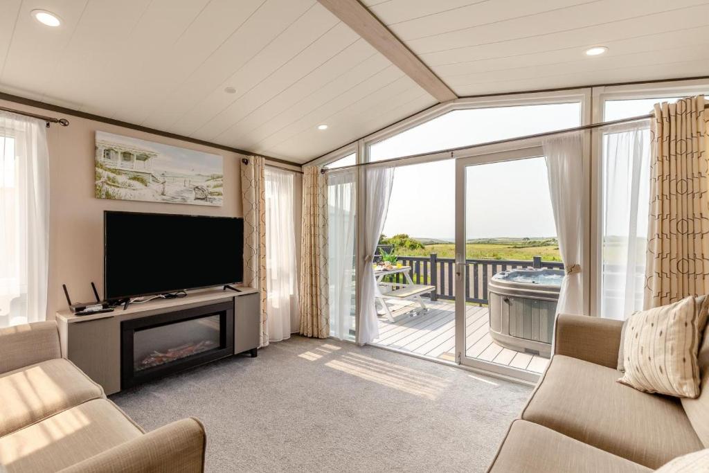 a living room with a television and a balcony at 2 Bed in Hendra Croft oc-h32360 in Cubert