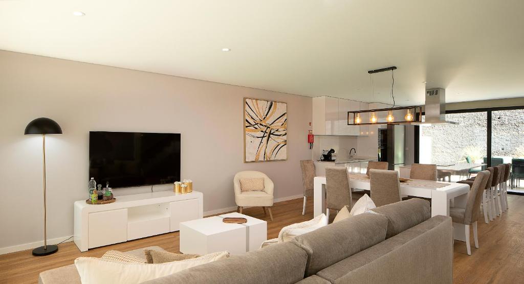 a living room with a couch and a dining room at Villa Joy, moderna e sofisticada in Funchal