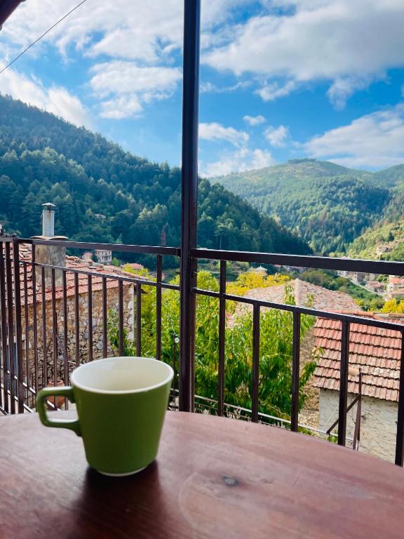 a coffee cup sitting on a wooden table with a view at Forrest Guesthouse in Polídhroson