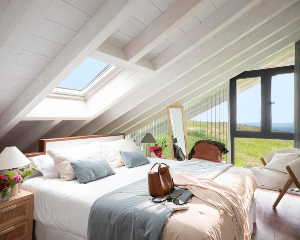 a bedroom with a large bed with a purse on it at Wishome- Villa sublime con piscina climatizada in Prellezo