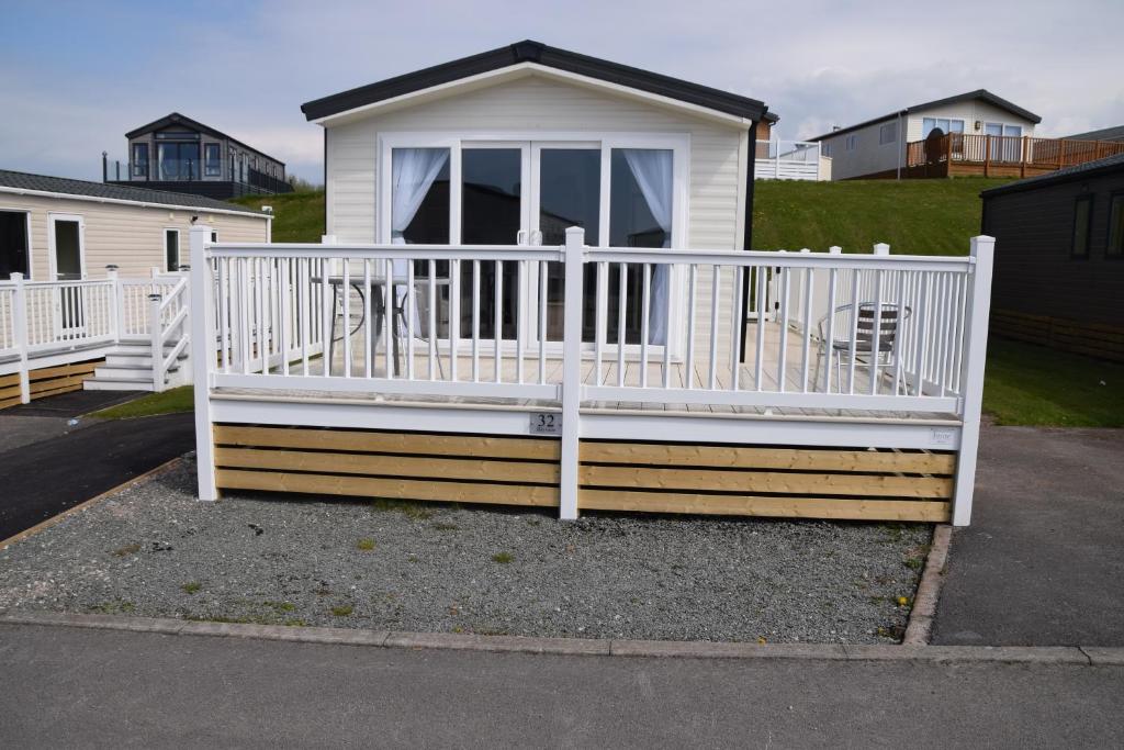 モアカムにあるPoppy Lodge LE 17 Ocean's Edge Parkの白い手すりと玄関のある家