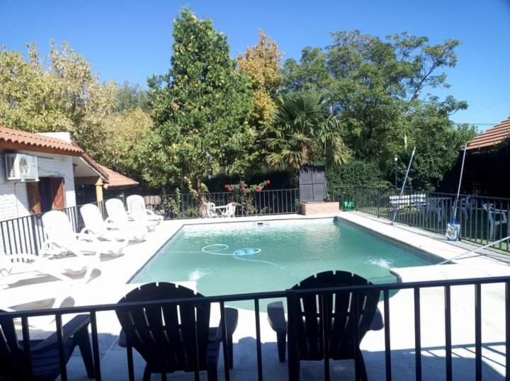 una pequeña piscina con sillas y una valla en Complejo Villa del sol, en Mina Clavero