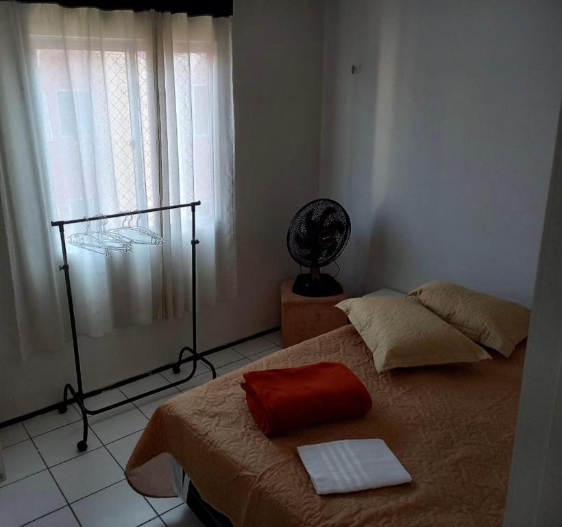 フォルタレザにあるApartamento Econômico e Aconchegante de 2 quartosのベッドルーム1室(ベッド1台、ファン、窓付)