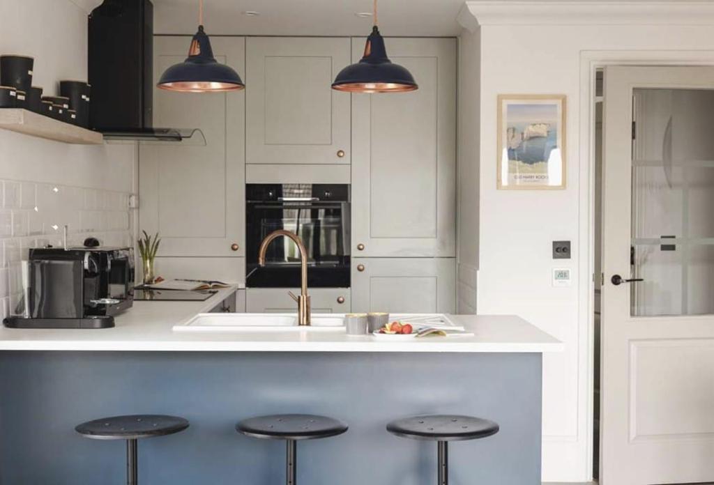 een keuken met een aanrecht met krukken erin bij 5 The Lookout - 2 bed apartment with parking, balcony & sea views in Swanage
