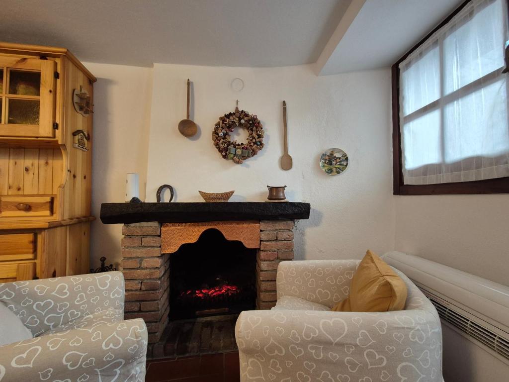 Una sala de estar con chimenea y una silla. en Casa Camilla, Casa Vacanze sulle colline di Lerma, en Lerma