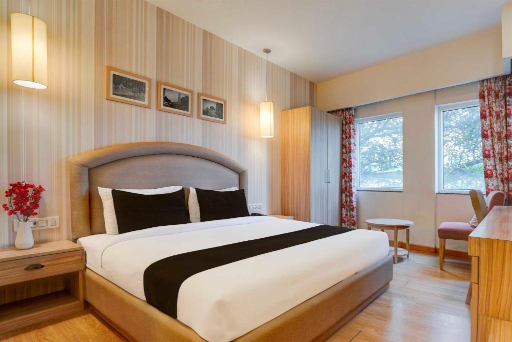 a bedroom with a large bed in a room at Townhouse Oak Sahastradhara Road Dehradun in Dehradun