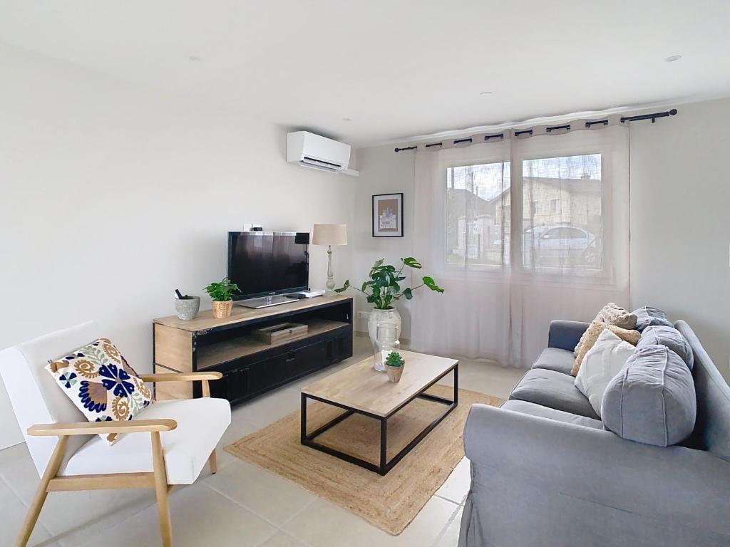 Una sala de estar con un sofá y un televisor. en NUIT ET JOUR à Chaumont, en Chaumont