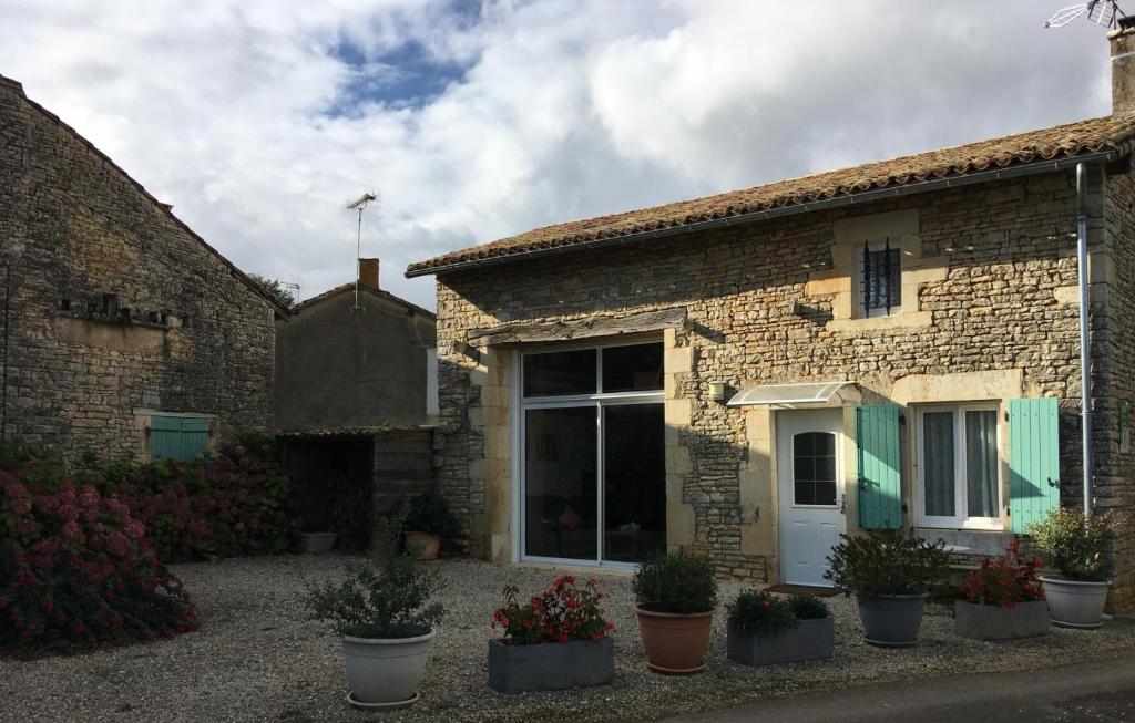a brick house with plants in front of it at L'ammonite in Chaunay