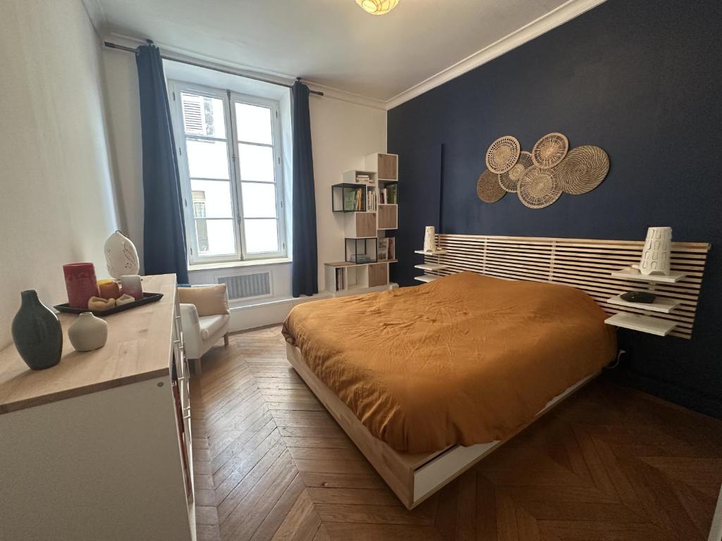 a bedroom with a large bed and a window at Herem Charme de l ancien en centre ville in Clermont-Ferrand