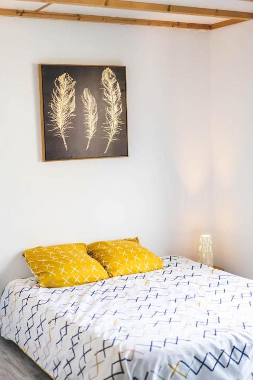 a bedroom with a bed with a picture on the wall at Le gite du marronnier in Montamisé