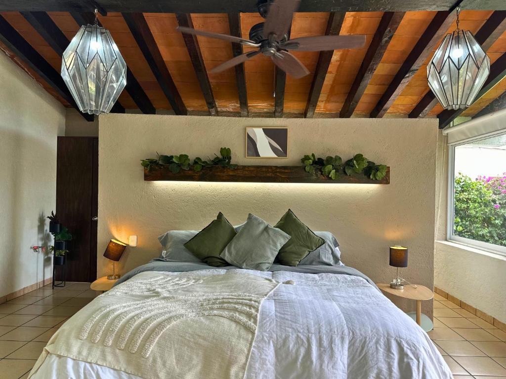 a bedroom with a bed with a ceiling fan at Casa Haru, Hermosa casa con alberca climatizada, jardín, asador y tombling, capacidad para 14 personas, 5 recámaras, 8 camas, 5 baños estacionamiento para 4 autos in Cuernavaca