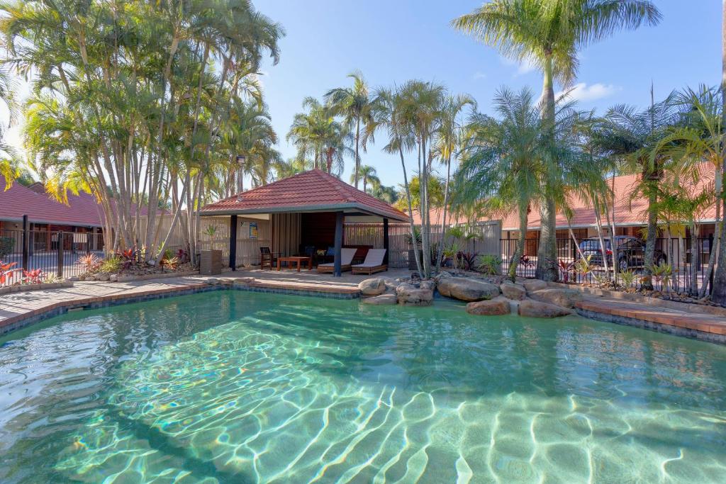a large swimming pool with a gazebo and palm trees at Brisbane International Virginia in Brisbane