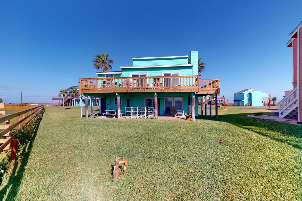 una casa con un ponte in cima a un prato di Seas the Day a Port Aransas