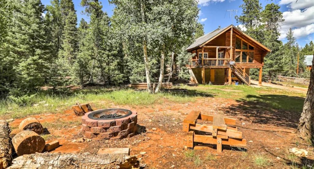 a log cabin with a fire pit in front of it at Cozy three bedroom cabin in Duck Creek in Duck Creek Village