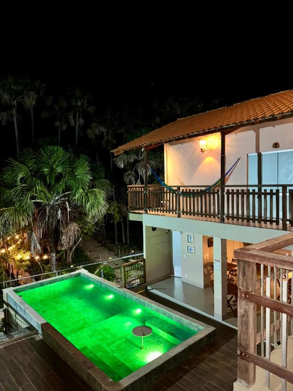 a swimming pool in front of a house at night at DECK DOS LENÇÓIS pousada in Barreirinhas