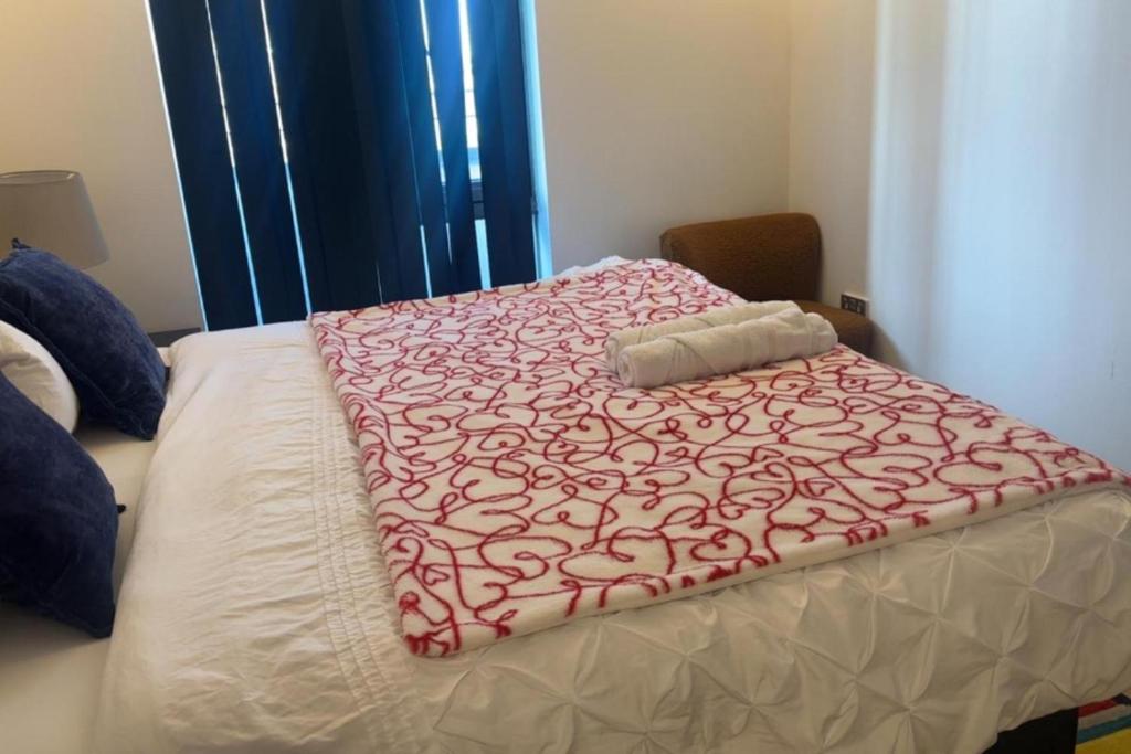 een bed met een rode en witte deken erop bij London 1 Bed Apartment close to Barking Station in Barking
