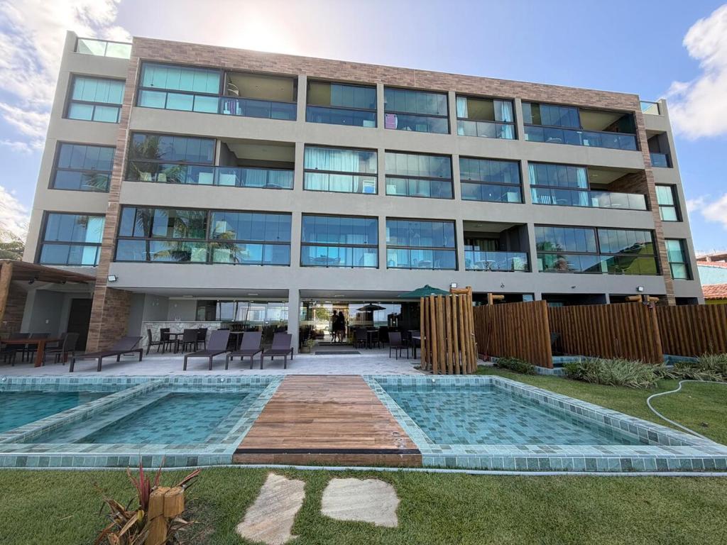 Un gran edificio con una piscina en frente. en Kauai 201 Tamandaré, en Tamandaré
