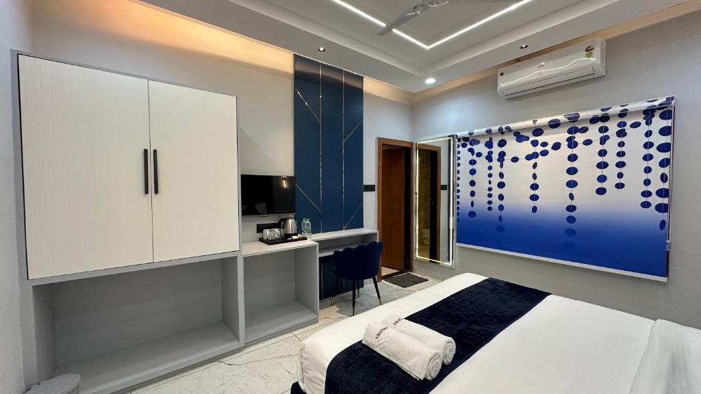 a bedroom with a white bed and a blue wall at The Hotel Phoenix Inn in Jāmb