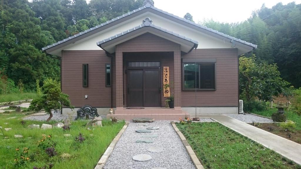 a small house with a front door in a yard at Fukuroutei in Sosa