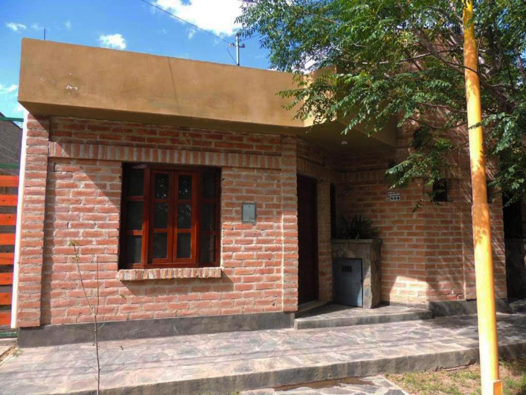 a brick house with a window and a door at Alojamiento Belén Catamarca - Planta Baja con Cochera Gratis in Belén