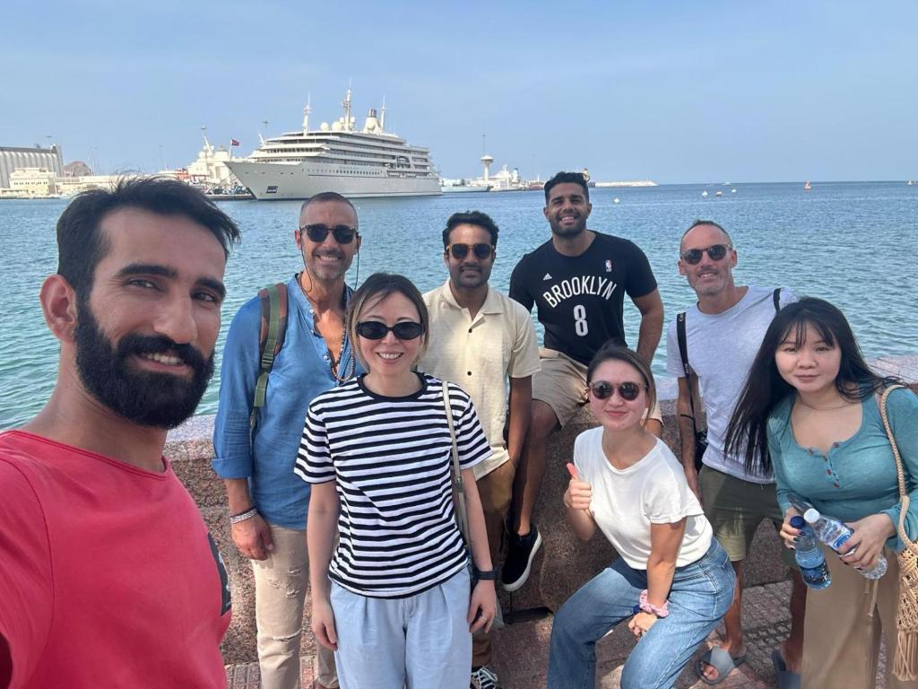a group of people posing for a picture by the water at Heritage Hostel Muscat in Muscat