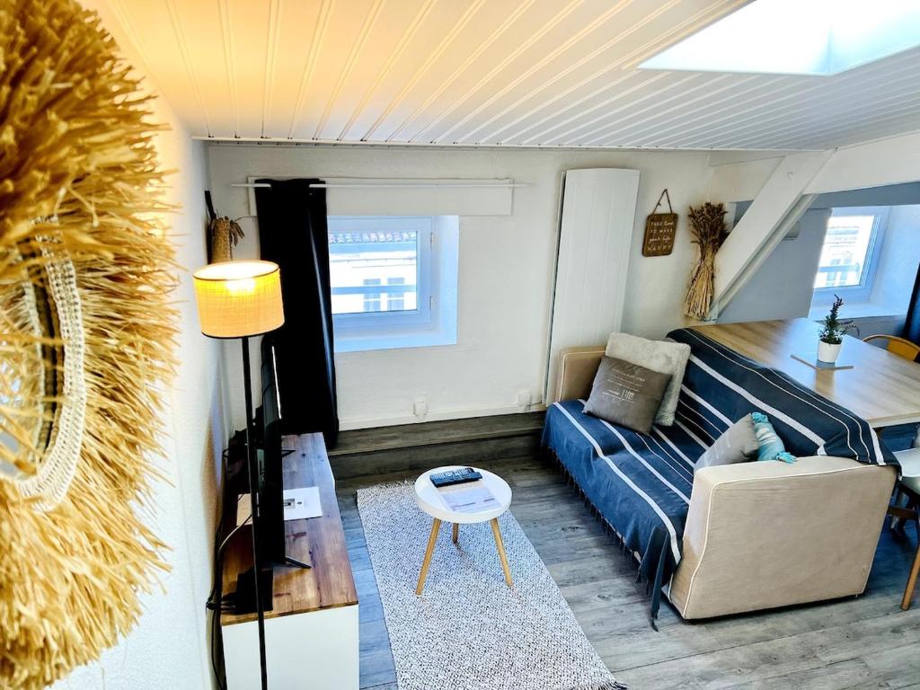 a living room with a blue couch and a table at Le Petit Réaumur - Coeur de ville in La Rochelle